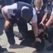Woman shouts 'get off his neck' as Merseyside Police officers pin suspect during arrest