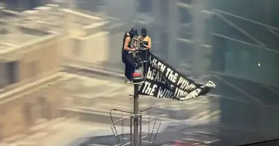 Two Masked People Climb Empire State Building, Fly Banner