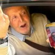 Beatles tour bus passengers see Sir Paul McCartney on phone with Ringo Starr