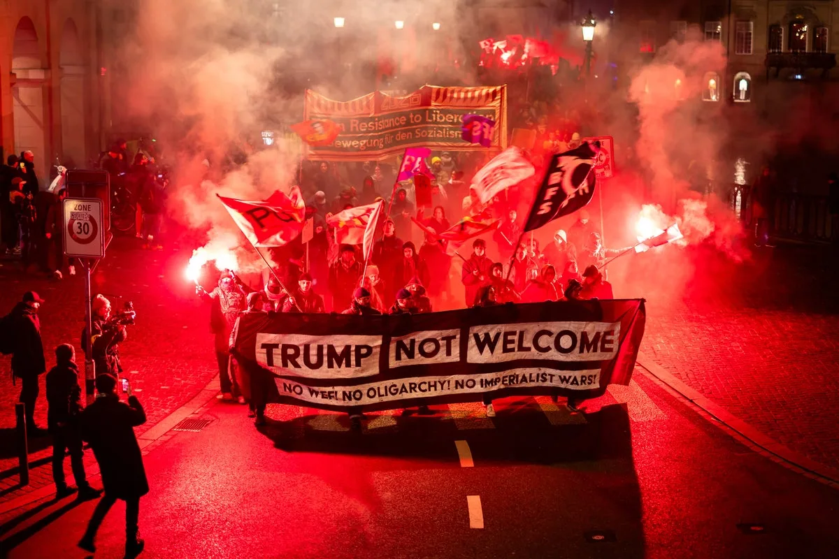 Swiss protesters burn US flags as Trump arrives for Davos over Greenland row