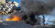 Ceuta beach fires as riot police clash with migrants