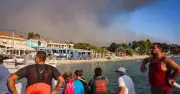 Tourists evacuated by boat as wildfire hits Greek resort