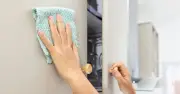Soapy water and microfibre cloth clean matte kitchen cupboards